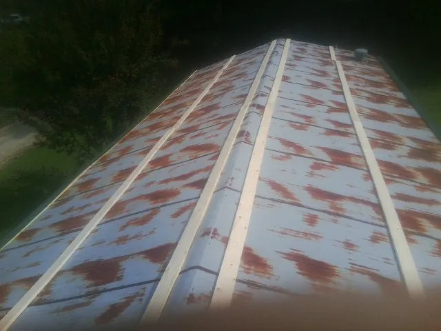 Rusted metal roof panels with new wood purlins before replacement — Storm Damage Roof Repair in Belspring by Roofing Brothers