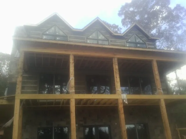 Dormers and porch framing on a large log home under construction — Roof Coating work by our crew in Belspring