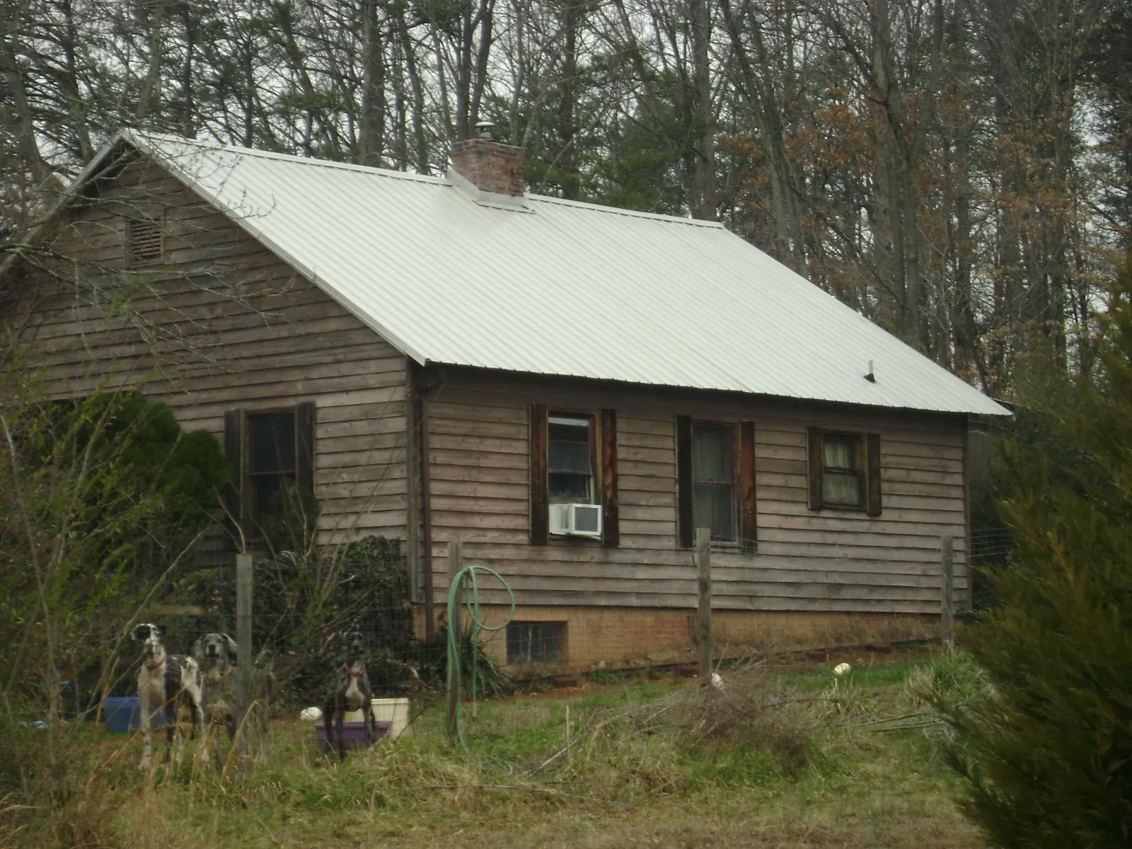 White metal roof on an old wood sided farmhouse, from a Metal Roof Installation job in Belspring